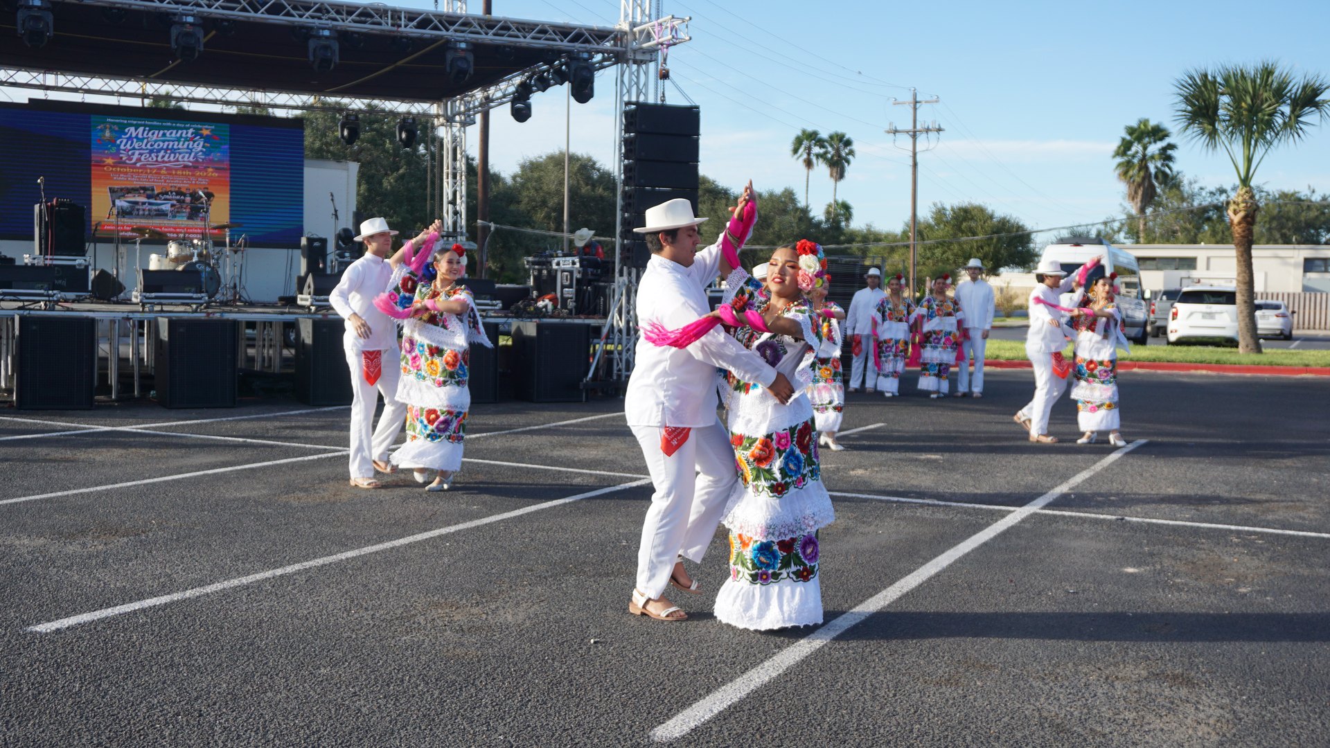 Dance partners turn together across the outdoor performance area.