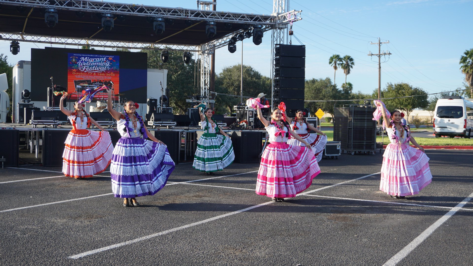 Dancers lift handkerchiefs and hold out their colorful skirts during a festival performance.
