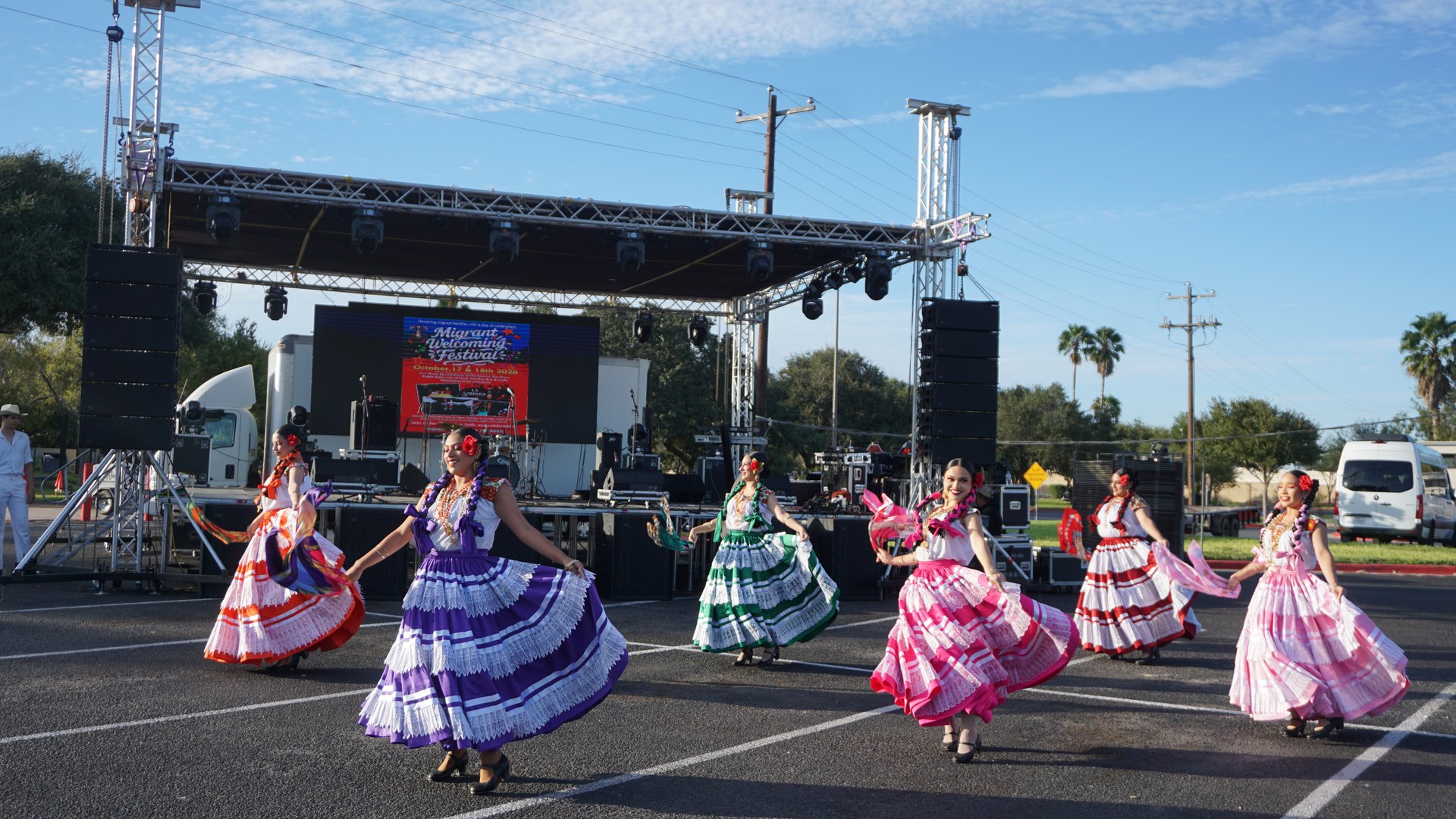 Dancers swirl their colorful tiered skirts across the outdoor performance area.