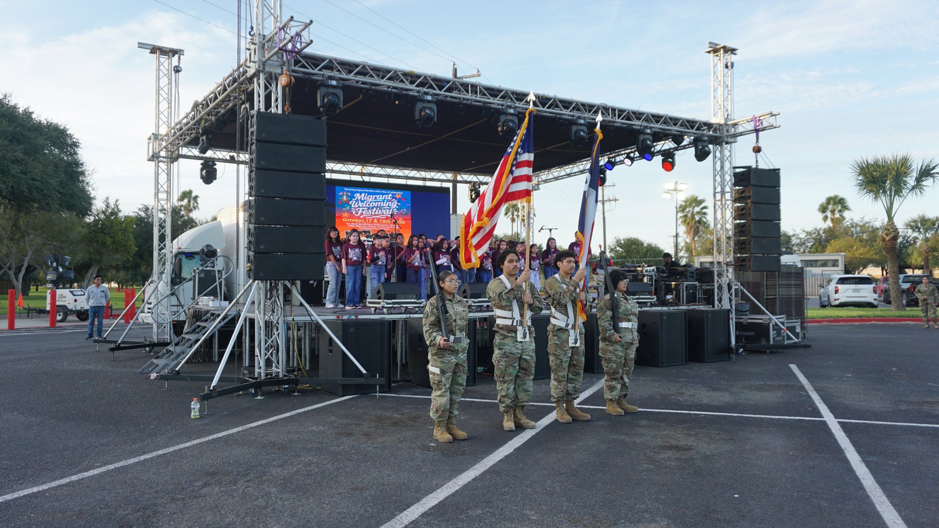 Uniformed flag bearers hold United States and Texas flags before the choir and festival stage.